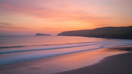 Obraz premium Serene sunset over a calm beach with gentle waves and distant hills.