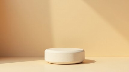 Cream-colored cylindrical pedestal bathed in soft sunlight against a pale backdrop, ideal for product display or minimalist aesthetic