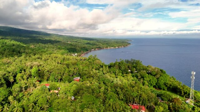 Aerial Drone tropical volcanic coastline of Camiguin Island the Philippines. Lush green Jungle, fertile soils, azure blue crystal clear waters ocean. 