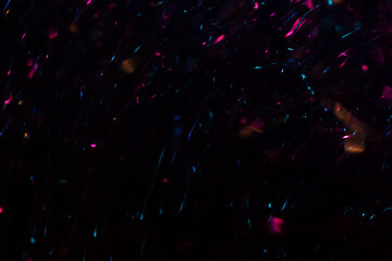 Blurred Sparkles of Pink, Yellow, and Blue Streaking Through a Dark Background, Creating a Dreamlike Glow