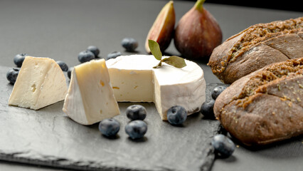 Fresh cheese and figs on a black table