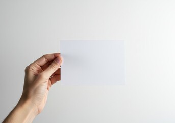 Obraz premium Hand holding paper, white background, close-up, minimal, clean, blank note, gesture, communication concept, isolated