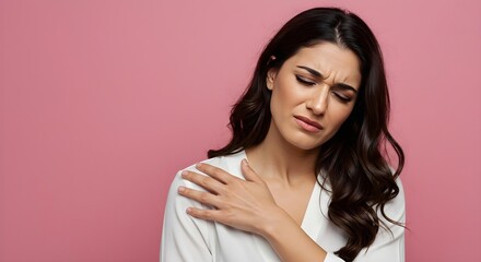 Woman in white shirt experiencing shoulder pain