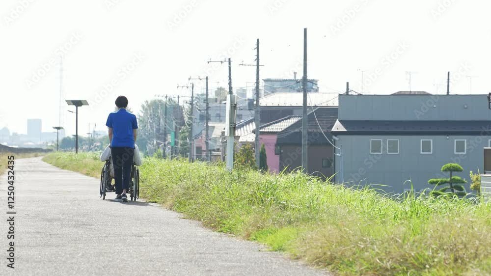 Fototapete 介護、車椅子、散歩、介護士、ヘルパー、後ろ姿、外出、屋外、歩道、サポート、デイサービス、シニア、高齢者、お年寄り、老人ホーム、施設、デイケア、レク、住宅街、公園、道、自然、青空、コピースペース、背中、福祉、ウェルネス、障害、障がい者、ボランティア、女性、男性、日本人、サービス、支援、フレイル、サルコペニア、哀愁、高齢化社会、老後、終活、ホームヘルパー、風景、広角、看護、見守り、介護福祉士、遠近感、