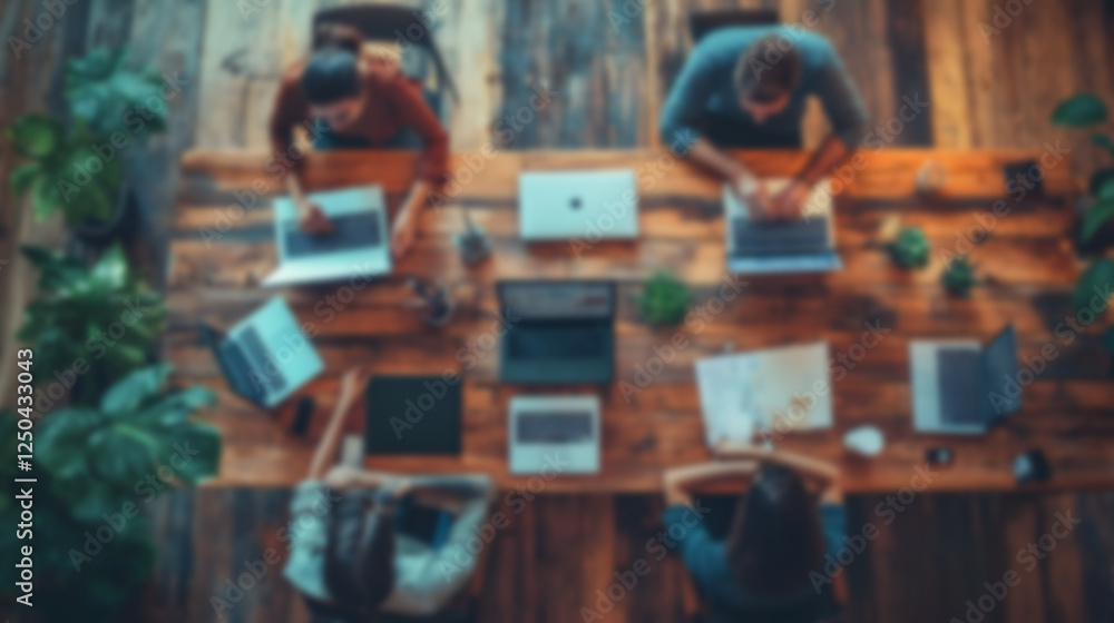 Poster Blur Two coworkers sitting at a wooden table with laptops collaborating on a project in a modern shared office workspace with plants and other office supplies The image depicts the concept of teamwork