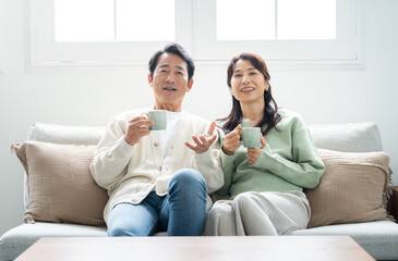 リビングでティータイムする50代夫婦