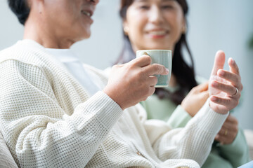 リビングでティータイムする50代夫婦