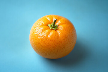 Fresh, juicy orange fruit on blue background. Top view
