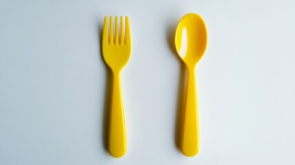 Green fork and spoon isolated on white background. Yellow colour objects. Eating. Kids fork and spoon. Kitchenwear. Tablewear. Simplicity. Scandinavian design. Product design. Comfort. Kids menu.