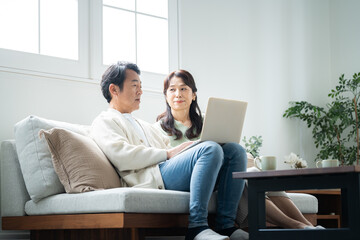 Obraz premium パソコンを見ながら会話する50代夫婦