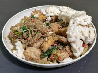 Rujak Cingur. Traditional Javanese food consisting of lontong with vegetables, peanut sauce, petis, tempeh, tofu, beef tongue, and crackers.