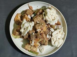 Rujak Cingur. Traditional Javanese food consisting of lontong with vegetables, peanut sauce, petis, tempeh, tofu, beef tongue, and crackers.