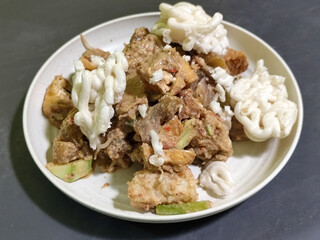 Rujak Cingur. Traditional Javanese food consisting of lontong with vegetables, peanut sauce, petis, tempeh, tofu, beef tongue, and crackers.