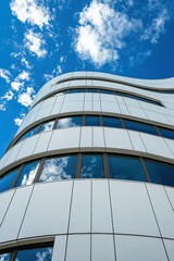 Futuristic Curved Metallic Building Under Blue Sky with Clouds
