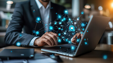 Businessman using laptop with network graphic overlay.