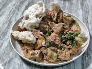 Rujak Cingur. Traditional Javanese food consisting of lontong with vegetables, peanut sauce, petis, tempeh, tofu, beef tongue, and crackers.