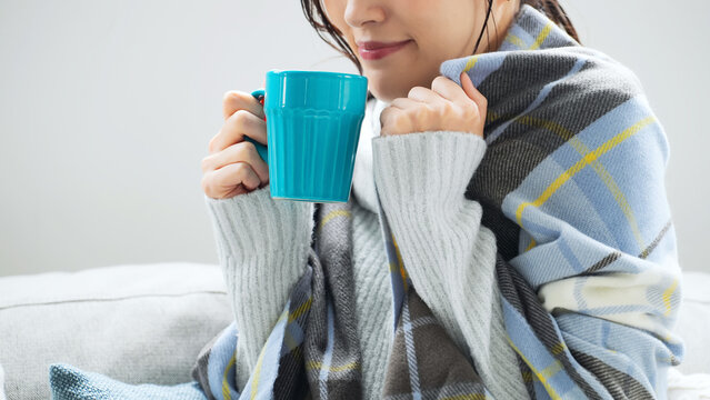 女性、停電、寒い、冬、コーヒー、日本人、防寒、発熱、風邪、寒暖差、ホットドリンク、紅茶、冷え性、凍える、リビングルーム、ライフスタイル、室内、部屋、自宅、ストール、マフラー、ショール、ブランケット、寒がり、寒さ、対策、エアコン、暖房、困る、悩む、カップ、飲み物、冷気、すきま風、室温、震える、若い、真冬、インテリア、気温、寒気、ラニーニャ現象、厳冬、温まる、天気、不安、心配、アレルギー、自律神経、人