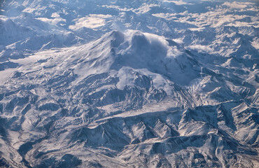 Caucasus mount Elbrus with snow peak in aerial winter scene. Aerial view from plane.