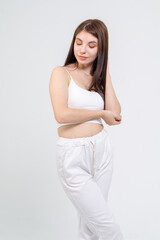 Young cute brunette girl standing on a white background. Copyspace