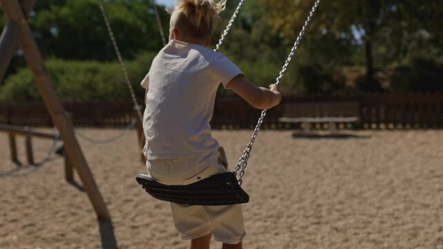 Joyful children swinging in a sunny park playground