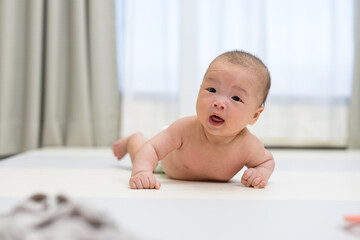 Baby trying to crawl on soft play mat