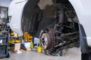 Repair of old brake pad in car service close-up.