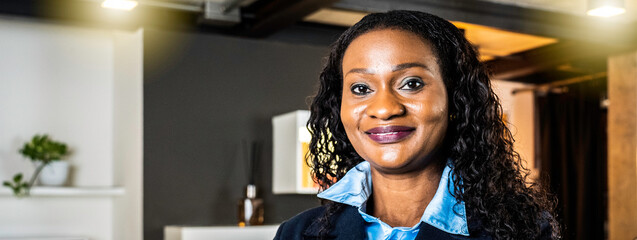 Horizontal banner or header with african businesswoman working inside modern office with the multiethnic team behind her - Concept of leadership and teamwork achieving goals - Focus on eyes