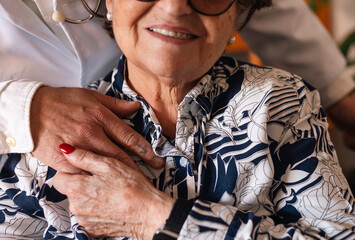 Doctor is holding hand of a cheerful senior woman patient, showing support and empathy