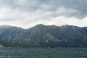 Mysterious fog over rocky mountain ridges in fjord
