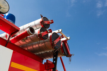 High-pressure water nozzle and blue siren light on a fire truck against blue sky. Emergency concept .