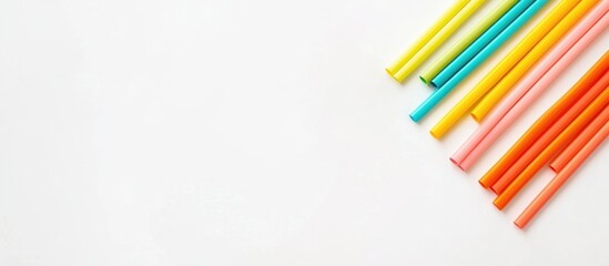 Fototapeta premium Colorful juice straws arranged in a row on a white background with ample copy space for promotions and advertising purposes