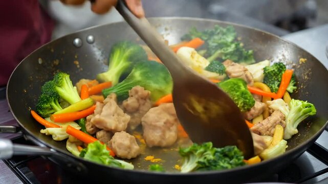 Stir Frying Chicken with Fresh Colorful Vegetables in a Wok