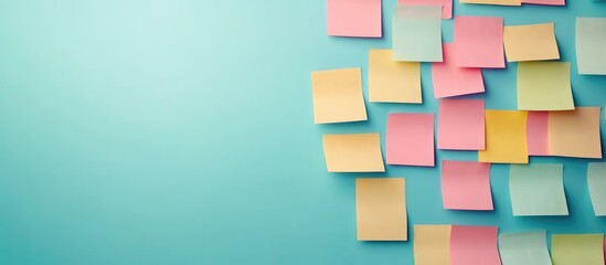 Office workers organizing colorful sticky notes on a teal wall creating a blank space for text and brainstorming ideas in a collaborative environment