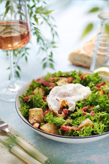 A bowl with salad lyonnaise served for lunch	