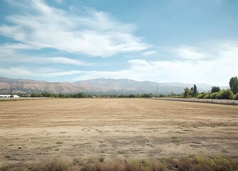 Photo of an empty field. Flat landscape with dirt field and blue sky background,