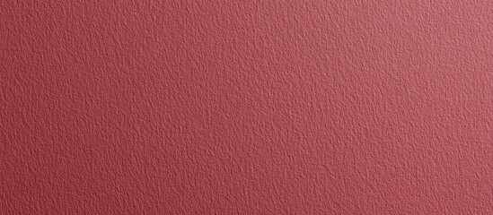 Fototapeta premium Textured dark red paper background showcasing a rich, deep hue ideal for design projects and creative presentations.
