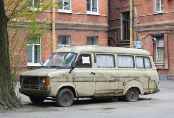 An old rusty minibus is parked in the courtyard of an apartment building, Staro-Peterhof Avenue, St. Petersburg, Russia, May 13, 2024