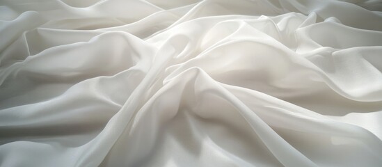 Soft white fabric texture with ripples and gentle folds, ideal for backgrounds and elegant design projects.