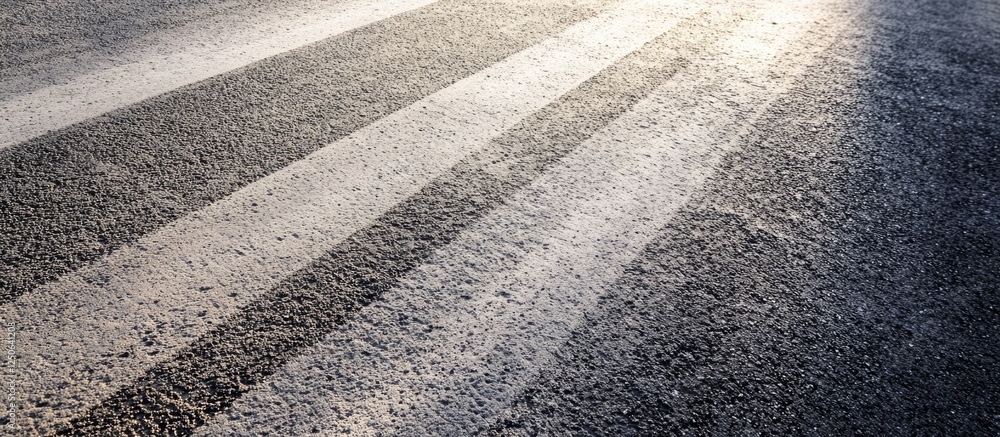 Poster concrete road surface texture with accentuated lines showcasing a blend of light and shadow effects.