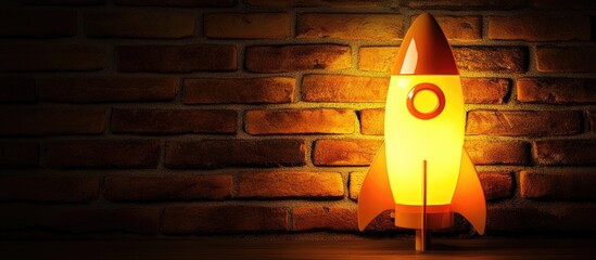 Rocket-shaped night lamp illuminating a brick wall creating a cozy ambiance with space for additional text or branding elements.