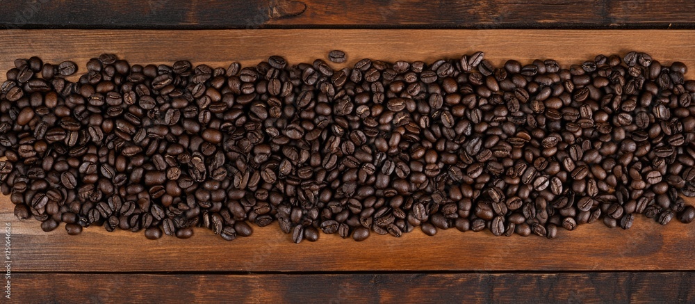 Poster roasted coffee beans on wooden surface creating a textured background perfect for beverage related d