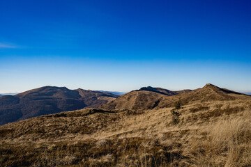 Scenic autumn landscapes from a trekking loop in Bieszczady, featuring views from Tarnica, Halicz, Rozsypaniec, Bukowe Berdo, Połonina Wetlińska, and the Ukrainian Bieszczady under a clear blue sky