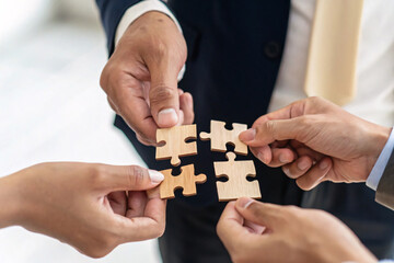 Teamwork and Partnership Concept, Businessman's Hands Connecting Puzzle Pieces, Symbolizing Unity, Charity, and Volunteer Collaboration