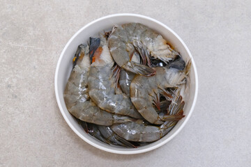Fresh shrimps on white bowl, food preparation.
