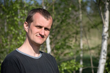 man portrait, European. the guy against the backdrop of nature. photo, smiling, thoughtful, surprised, indignant, feelings, emotions. fair skin, slight stubble. man 30-40 years old. close-up