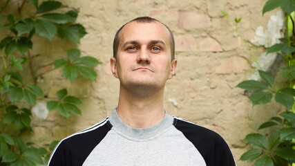 Kyiv, Ukraine, 11.06.2021. man portrait, close-up. the guy at brick wall. photo, smiling, thoughtful, surprised, indignant, feelings, emotions. fair skin. man 30-40 years old. European. editorial