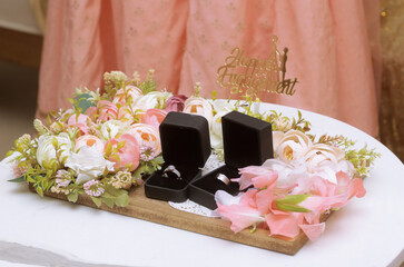 Color roses and engagement ring box styled beside a plate, wedding rings and roses, wedding ring...