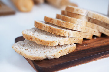 Homemade freshly sliced bread on a wooden cutting board in kitchen