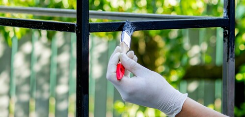 close up of painting metal with brush in garden.