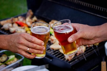 two glasses of beer against the background of a barbecue. recreation. nature.